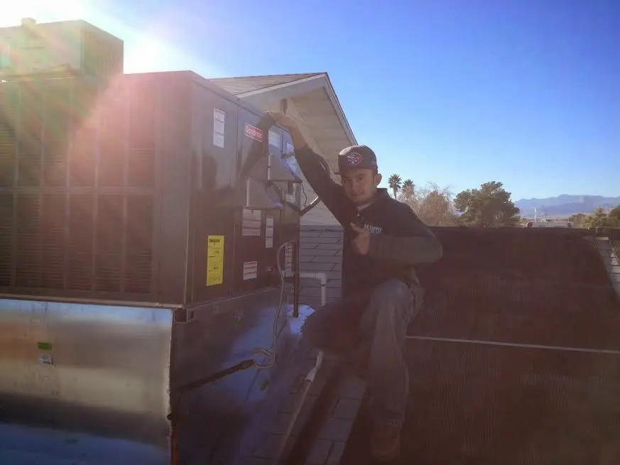 HVAC technician performing AC Tune-Up on a rooftop unit in Shelley